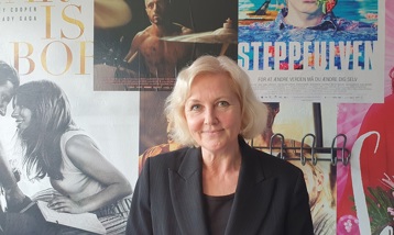 Anne-Marie Vedsø Olesen står foran klassiske biografplakater i Biffen i Aalborg.